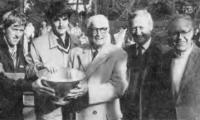Killy Kilmarx (center), the winner of the first Men's Championship with Clifford Couch in 1935, presents the Championship bowl to the fifty-second championship pair of Hank Irvine (left) and Greg Moore. Dick Warren (right), FMTC president, and Paul Molloy, tournament chairman.