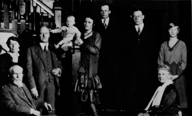 Forty-five years after the founding of the Club, first President Thomas Burgess stands at left for a family portrait in Colonel Alexander B. Crane’s entrance hall.  